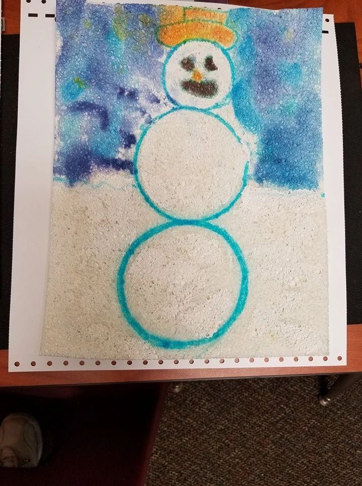 A crayon and watercolour drawing of a snowman with a hat, made using a raised-line technique so the outline can be felt as well as seen, against a textured blue and white background.