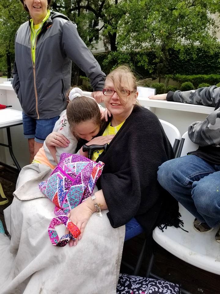 Two people share an embrace on the float, one resting their head against the other's shoulder, with a patterned quilted item nearby.