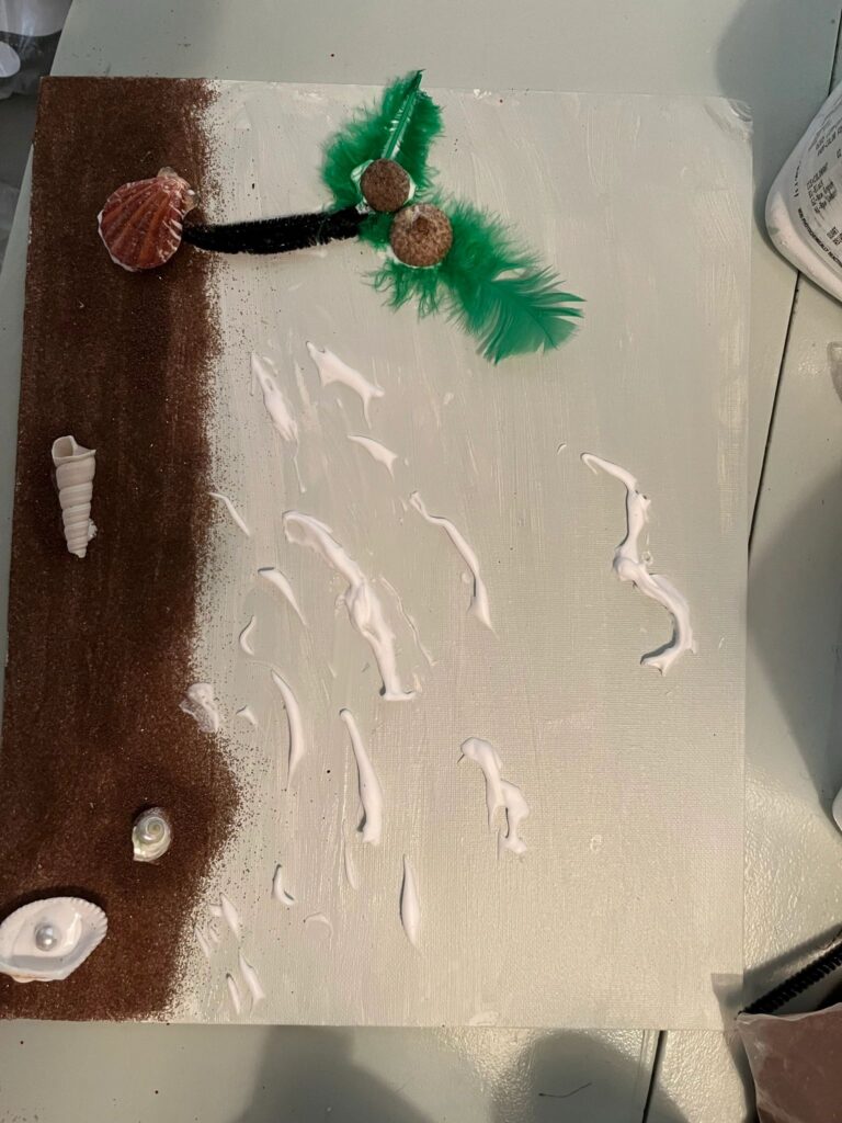A finished beach canvas with a green feather and cork palm tree, a shell trunk base, and rows of white glue tracing wave patterns on a cream background.